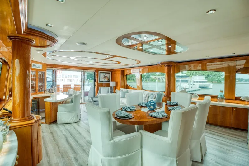 Slide: The Image of Luxurious interior of 2007 Hatteras 80 Enclosed Bridge yacht with elegant dining area and large windows. - 6