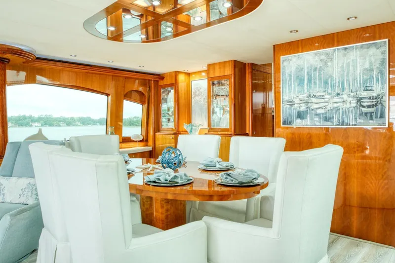 Slide: The Image of Luxurious dining area on 2007 Hatteras 80 Enclosed Bridge yacht with elegant wood finishes. - 8