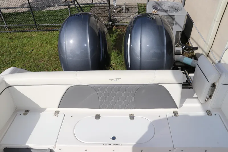 Slide: The Image of 2020 Tidewater 252 LXF boat with dual outboard engines and cushioned seating. - 11