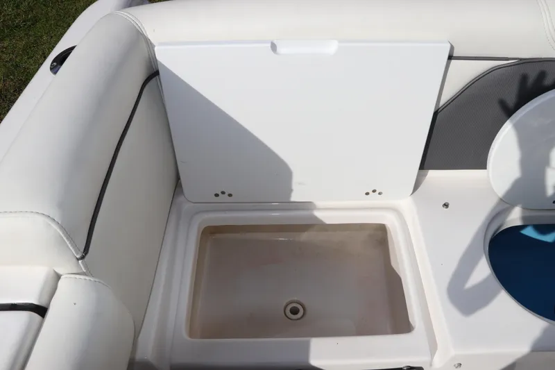 Slide: The Image of 2020 Tidewater 252 LXF boat interior storage compartment with white cushioned seating. - 12