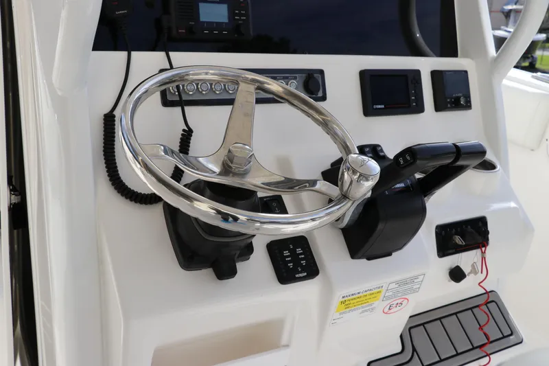 Slide: The Image of 2020 Tidewater 252 LXF boat helm with steering wheel and control panel. - 29