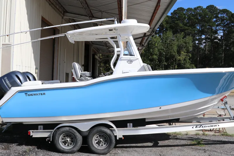 Slide: The Image of 2020 Tidewater 252 LXF boat on trailer, blue hull, parked outdoors. - 3