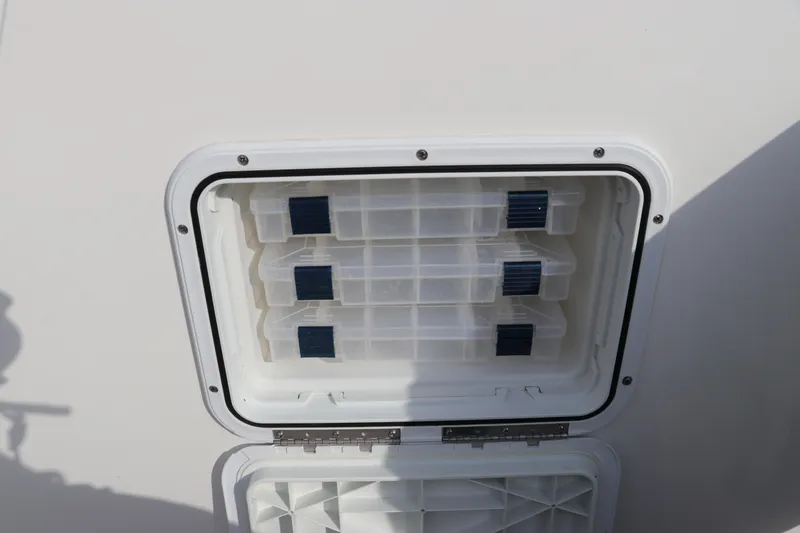 Slide: The Image of Tidewater 252 LXF 2020 boat storage compartment with organized tackle boxes. - 36