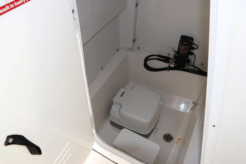 Slide: The Image of 2020 Tidewater 252 LXF boat interior with compact marine toilet and pump system. - 39