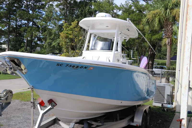 Slide: The Image of 2020 Tidewater 252 LXF boat on trailer, blue hull, parked outdoors. - 4