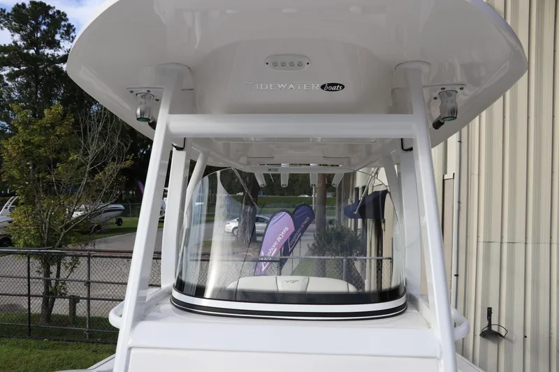 Slide: The Image of 2020 Tidewater 252 LXF boat with T-top and clear windshield, outdoor setting. - 56