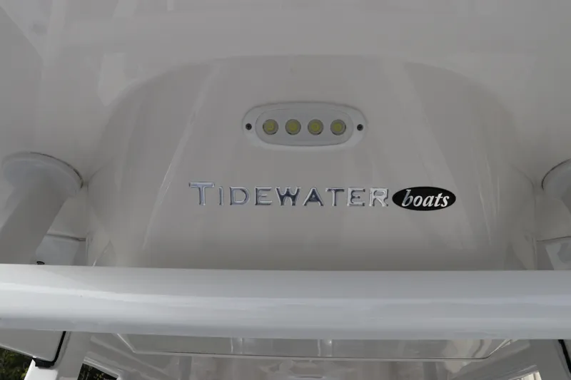 Slide: The Image of 2020 Tidewater 252 LXF boat logo with LED lights on white surface. - 57