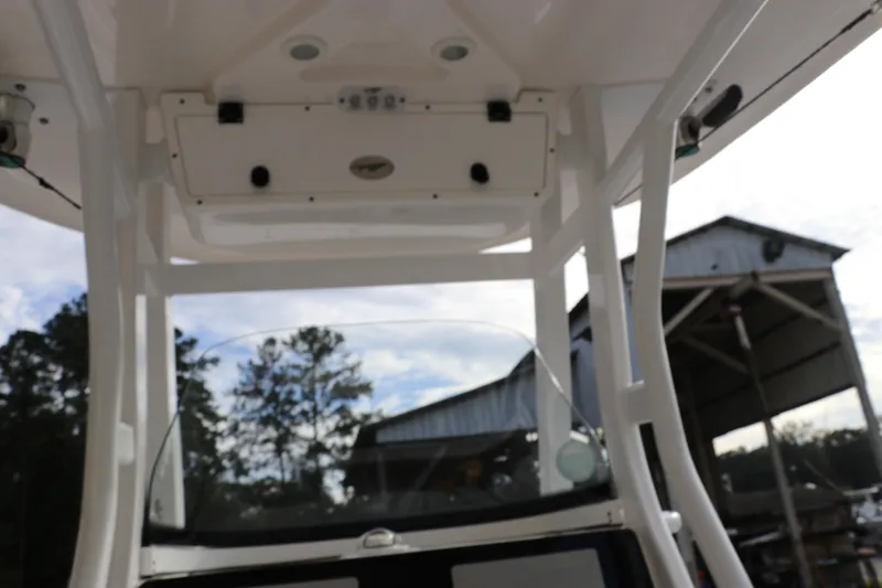 Slide: The Image of 2020 Tidewater 252 LXF boat interior with overhead console and outdoor background. - 58