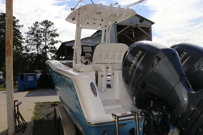 Slide: The Image of 2020 Tidewater 252 LXF boat with dual Yamaha engines, parked outdoors. - 6