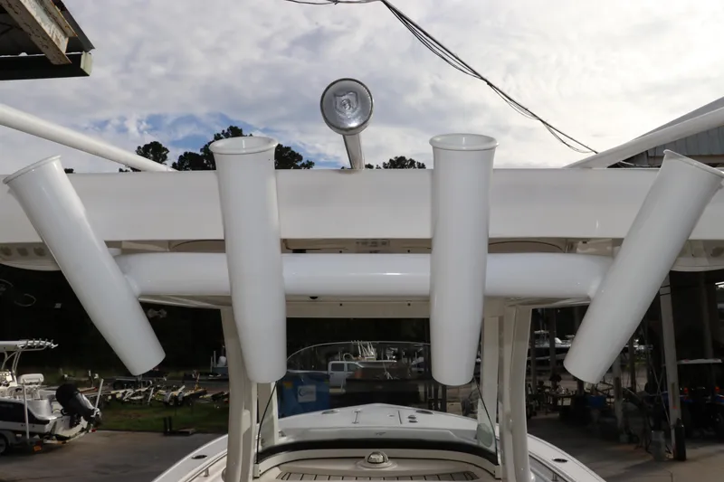 Slide: The Image of 2020 Tidewater 252 LXF boat with rod holders and spotlight, docked outdoors. - 60