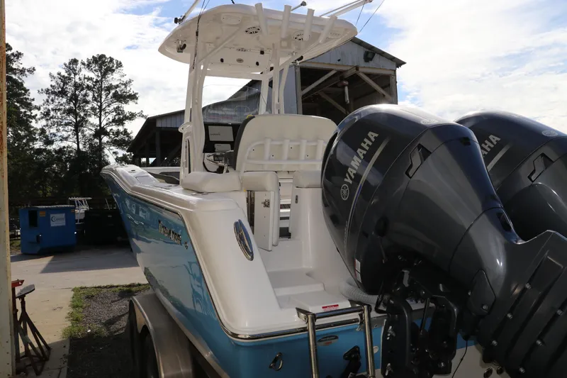 Slide: The Image of 2020 Tidewater 252 LXF boat with dual Yamaha engines, parked outdoors. - 7