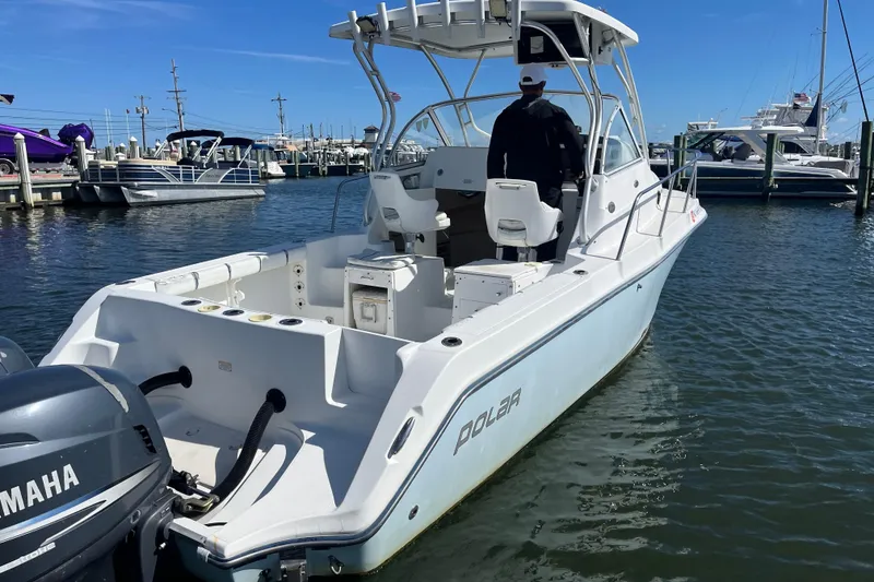 Slide: The Image of 2005 Polar 2300 Walkaround boat docked, featuring Yamaha outboard motor. - 1