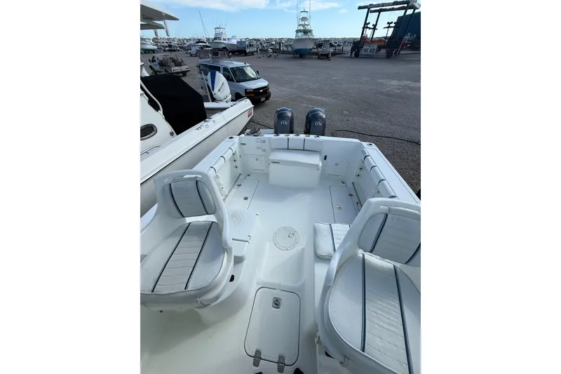 Slide: The Image of 2005 Polar 2300 Walkaround boat interior with seating and twin engines in a marina setting. - 12