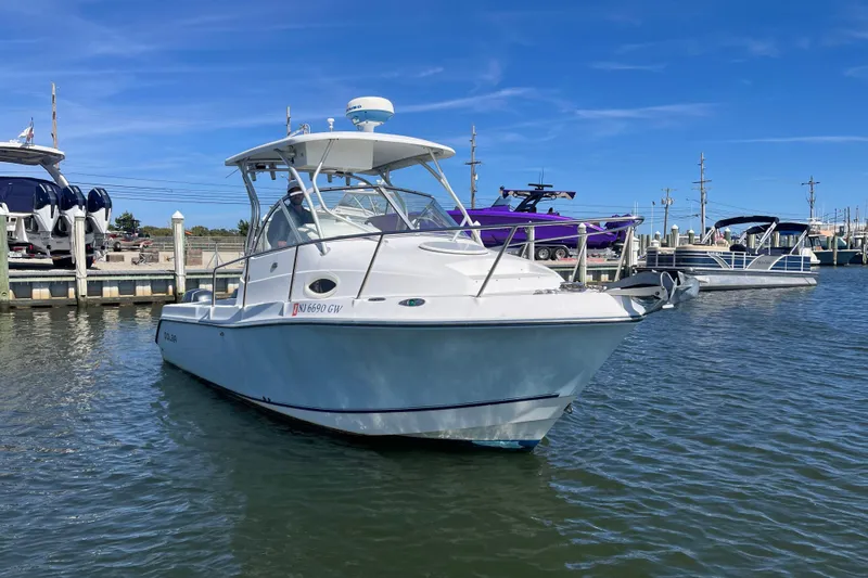 Slide: The Image of 2005 Polar 2300 Walkaround boat docked in a marina under clear blue skies. - 3