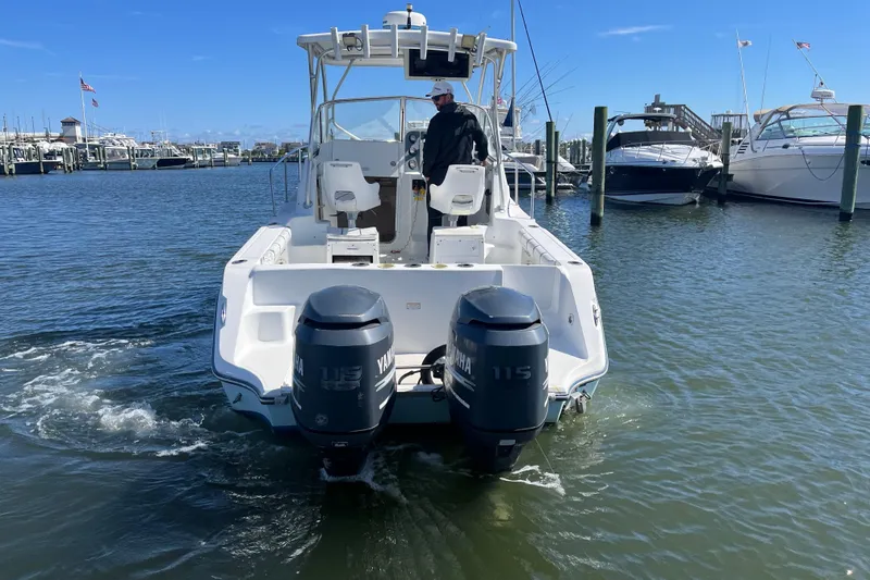 Slide: The Image of 2005 Polar 2300 Walkaround boat with dual Yamaha engines in a marina setting. - 4