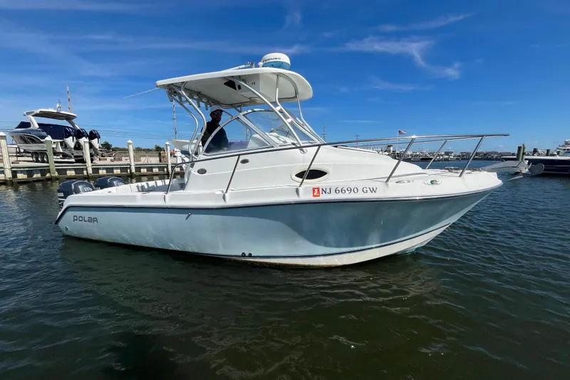 Slide: The Image of 2005 Polar 2300 Walkaround boat docked in marina under clear blue sky. - 5