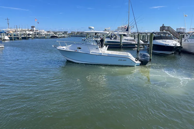 Slide: The Image of 2005 Polar 2300 Walkaround boat docked in a marina under clear blue skies. - 6
