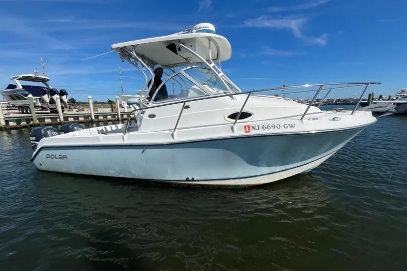 Slide: The Image of 2005 Polar 2300 Walkaround boat docked in marina, clear blue sky background. - 7