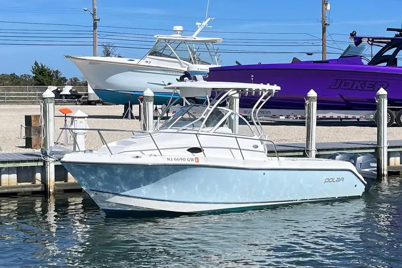 Slide: The Image of 2005 Polar 2300 Walkaround boat docked at marina, clear blue sky background. - 8