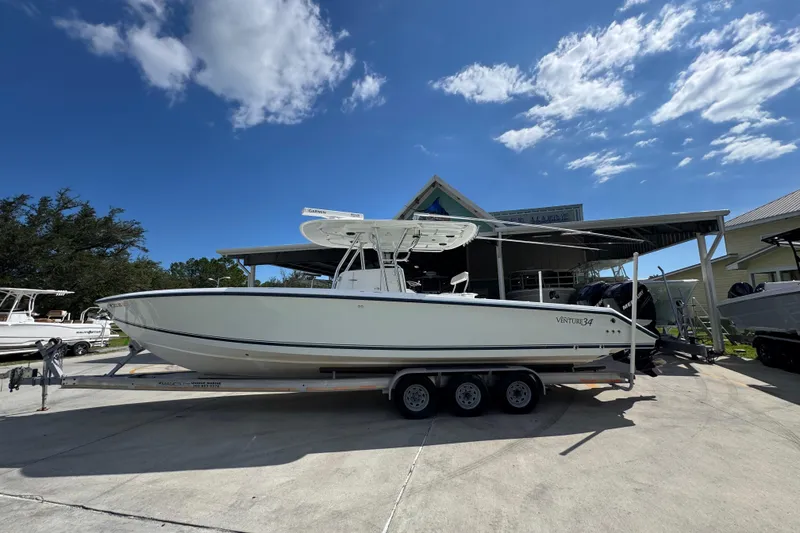 The Image of 2007 Venture 34 Open boat on trailer under clear blue sky. - 1
