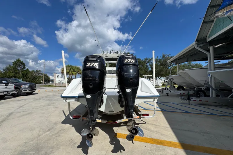 Slide: The Image of 2007 Venture 34 Open boat with twin 275 horsepower engines, parked outdoors under a clear sky. - 14
