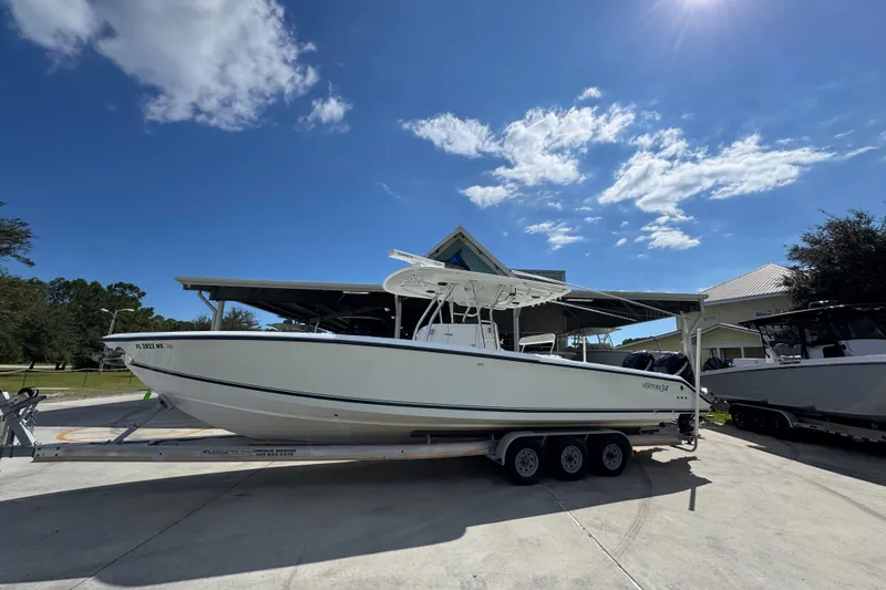 Slide: The Image of 2007 Venture 34 Open boat on trailer under clear blue sky. - 2