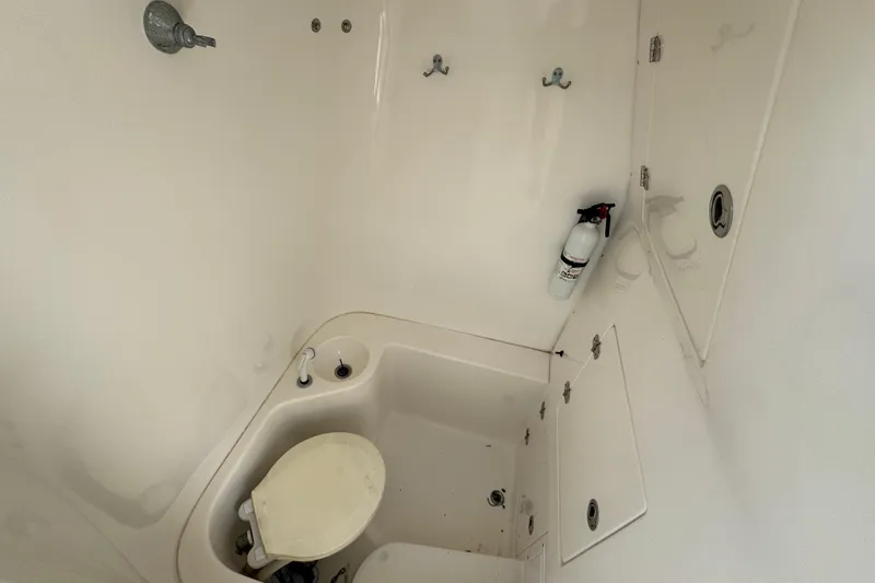 Slide: The Image of 2007 Venture 34 Open boat bathroom with toilet, fire extinguisher, and storage compartments. - 26