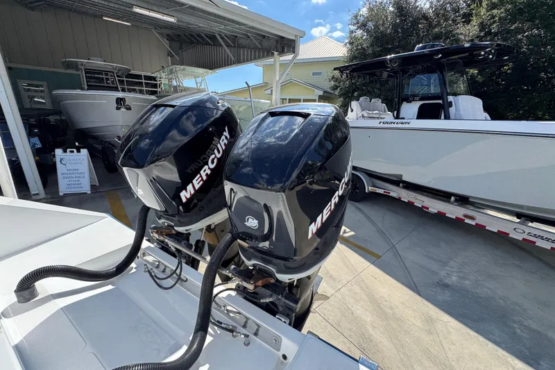 Slide: The Image of Twin Mercury outboard engines on a 2007 Venture 34 Open boat, parked near a trailer. - 39