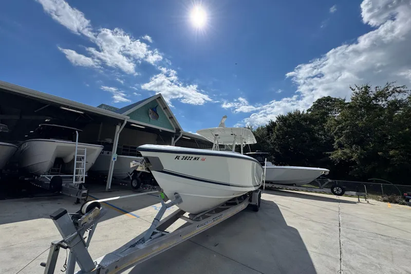 Slide: The Image of 2007 Venture 34 Open boat on trailer under sunny sky, parked near a building. - 5