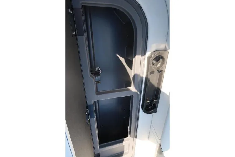 Slide: The Image of Storage compartment of 2026 Bennington S Swingback 22 SSB boat, featuring sleek design and cup holders. - 25