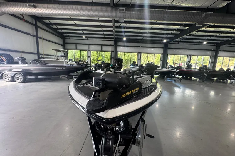 Slide: The Image of 2011 Skeeter ZX225 boat in showroom with other boats, featuring Minn Kota trolling motor. - 13