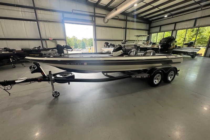 Slide: The Image of 2011 Skeeter ZX225 boat in showroom, side view, on trailer, with visible outboard motor. - 15