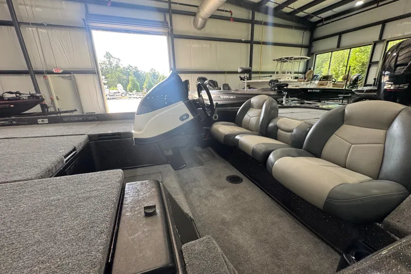 Slide: The Image of 2011 Skeeter ZX225 boat interior with gray seating in a spacious showroom. - 16