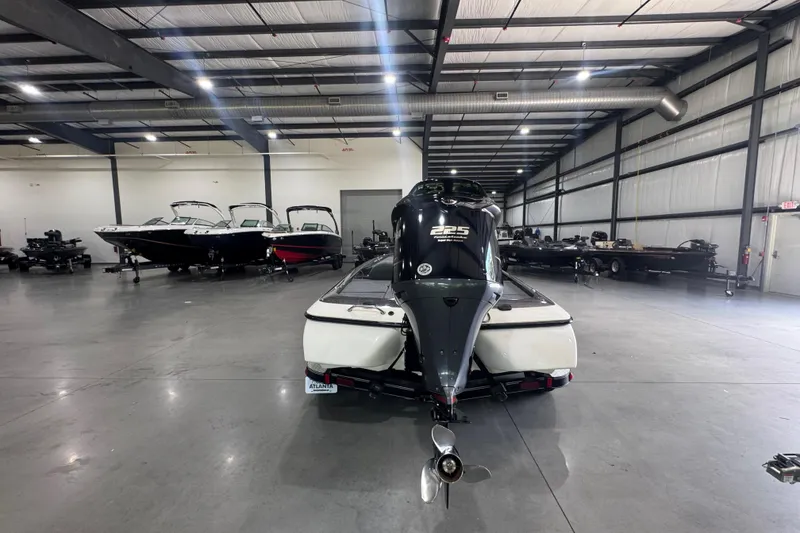 Slide: The Image of 2011 Skeeter ZX225 boat in a spacious indoor showroom with other boats. - 19