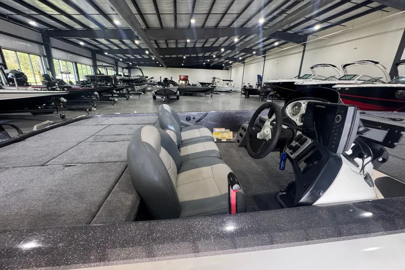 Slide: The Image of 2011 Skeeter ZX225 boat interior in showroom, featuring dual seats and steering console. - 5