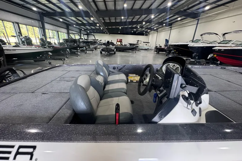 Slide: The Image of 2011 Skeeter ZX225 boat interior in showroom, featuring dual seats and steering console. - 8