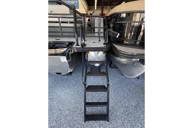 Slide: The Image of 2026 Starcraft EXS 3 boat with ladder, displayed indoors on speckled flooring. - 19