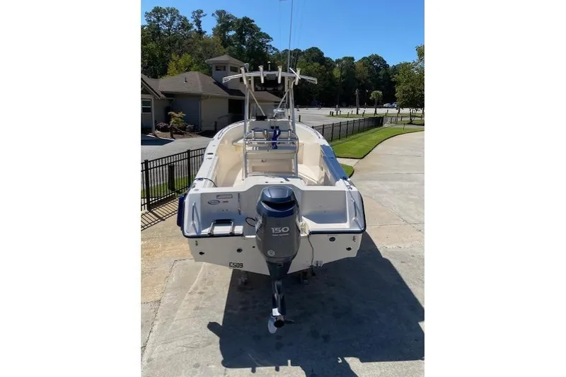 Slide: The Image of 2004 Sea Hunt Triton 220 boat with 150 HP outboard motor, parked on driveway. - 3