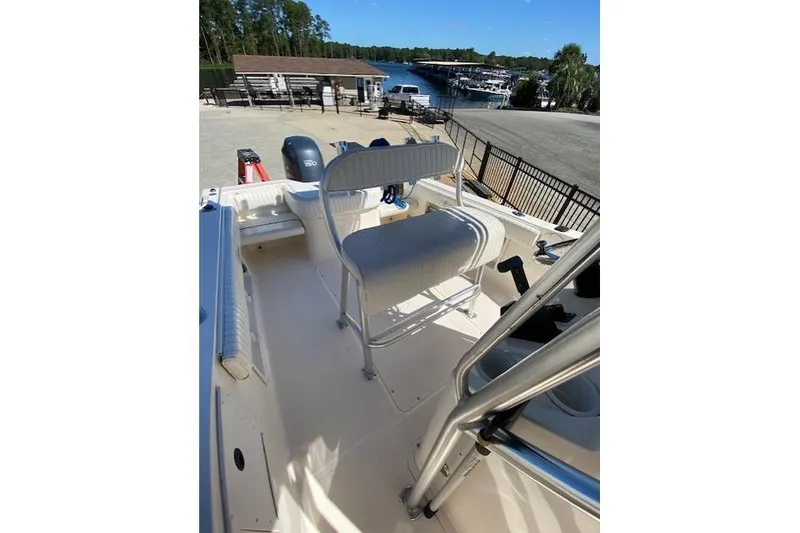 Slide: The Image of 2004 Sea Hunt Triton 220 boat interior with seating and view of marina. - 7