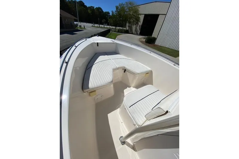 Slide: The Image of 2004 Sea Hunt Triton 220 boat interior with white cushioned seating. - 9