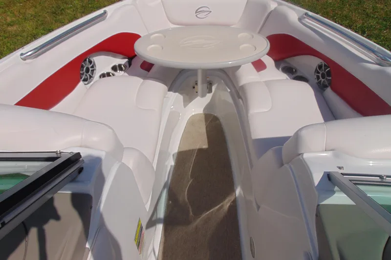 Slide: The Image of 2013 Crownline 235 SS boat interior with white and red seating, table, and speakers. - 11
