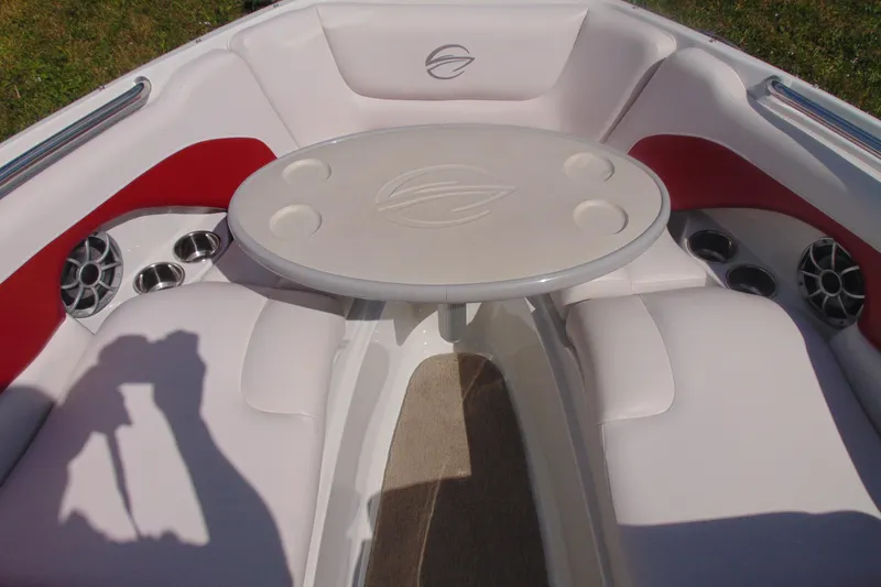 Slide: The Image of 2013 Crownline 235 SS boat interior with white seating, red accents, and a round table. - 12