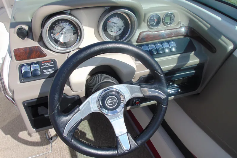 Slide: The Image of Steering wheel and dashboard of 2013 Crownline 235 SS boat, featuring gauges and controls. - 17