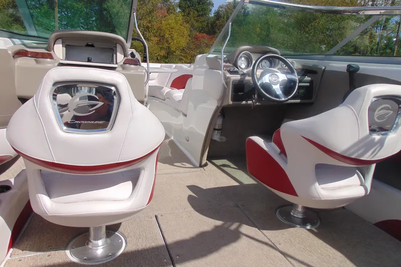 Slide: The Image of 2013 Crownline 235 SS boat interior with white and red seating, steering wheel, and dashboard. - 22