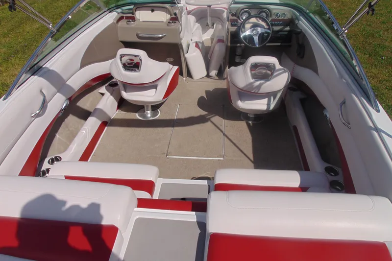 Slide: The Image of 2013 Crownline 235 SS boat interior with red and white seating, steering wheel, and dashboard. - 9
