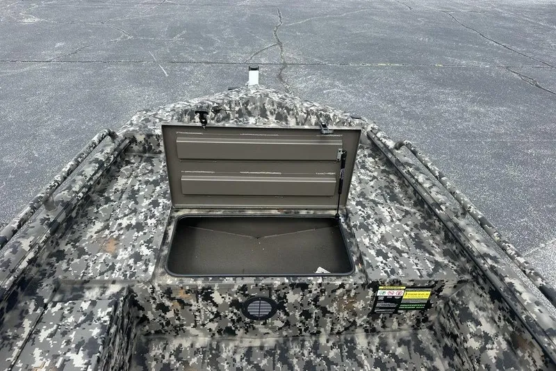 Slide: The Image of Camouflage-patterned 2025 Havoc 1656 boat with open storage compartment on asphalt surface. - 10