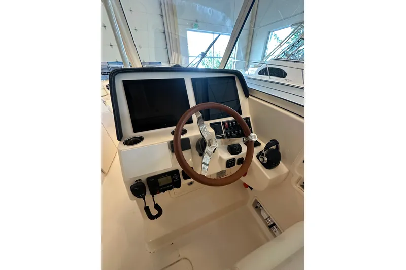 Slide: The Image of 2019 Grady-White Freedom 325 boat helm with dual screens and steering wheel. - 10