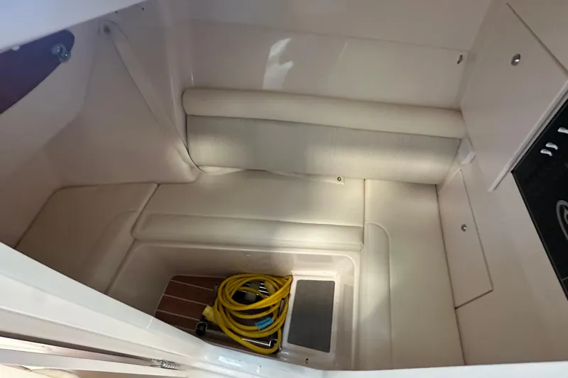 Slide: The Image of 2019 Grady-White Freedom 325 interior cabin with seating and coiled yellow hose. - 15