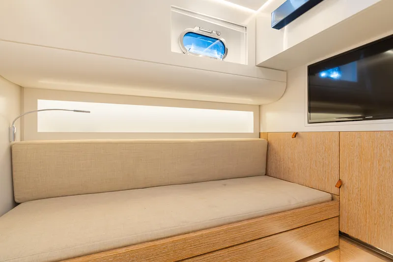 Slide: The Image of Modern interior of 2019 CNM Continental 54T yacht with sofa, TV, and porthole window. - 23