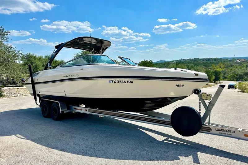 Slide: The Image of 2011 Rinker 276 Captiva boat on trailer under clear blue sky. - 13